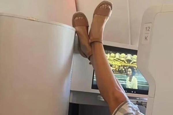 Woman with feet on back of passenger's seat.