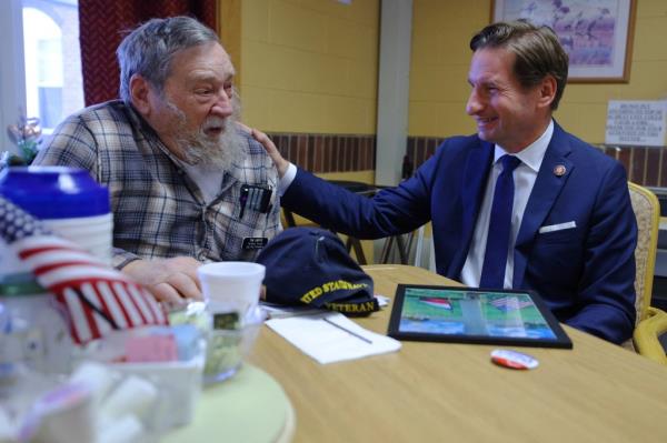 Democratic presidential candidate U.S. Representative Dean Phillips (D-MN) and U.S. Navy veteran Tom Sawyer, both Gold Star sons, talk during a campaign stop at the New Hampshire Veterans Home in Tilton, New Hampshire.