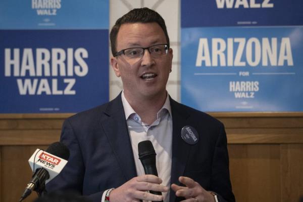 Gabe Hagen, owner of Brick Road Coffee, speaking at a microphone during an Arizona Small Business for Harris-Walz event at Orchard Tavern, Phoenix