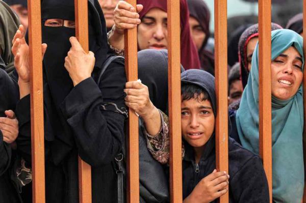 People mourn as they stand behind a me<em></em>tal fence near the bodies of victims who were killed in Israeli bombardment before their burial, outside the morgue at Nasser hospital in Khan Yunis in the southern Gaza Strip on Nov. 14, 2023. 