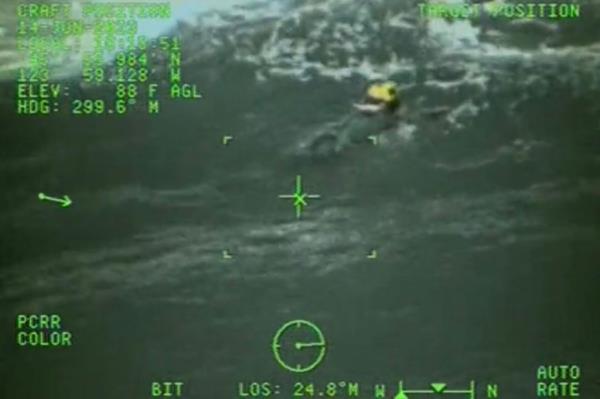 Rescuer swims toward the dog.