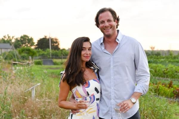 Candice and Brandon Miller standing together in a field at an event in Amagansett, NY in 2019