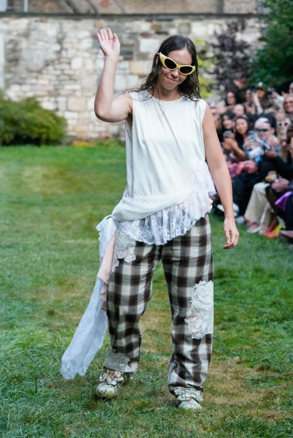 Hillary Taymour wearing a white top and plaid pants with yellow sunglasses walking the runway for Collina Strada at New York Fashion Week Spring 2025