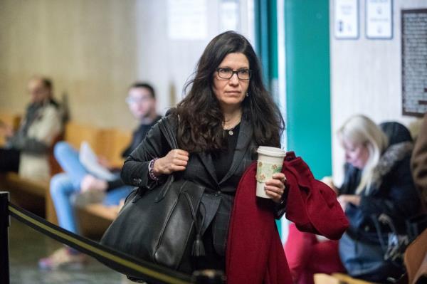 Forensic psychiatrist Karen Rosenbaum holds a cup of coffee as she enters a courtroom.
