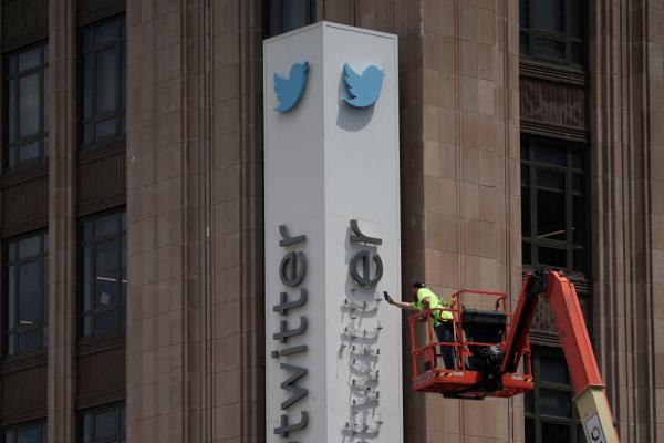 A worker dismantles the Twitter sign at Twitter's corporate headquarters in downtown San Francisco after Elon Musk renamed Twitter to X and unveiled a new logo.