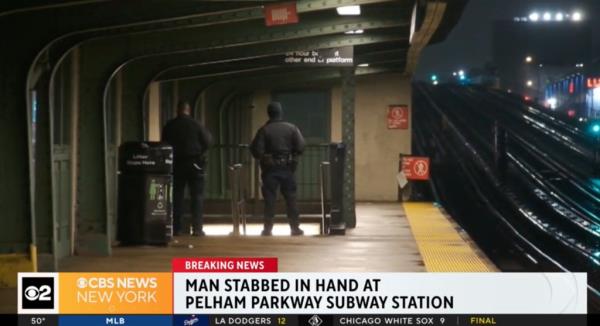 A man standing in a subway station platform at night.
