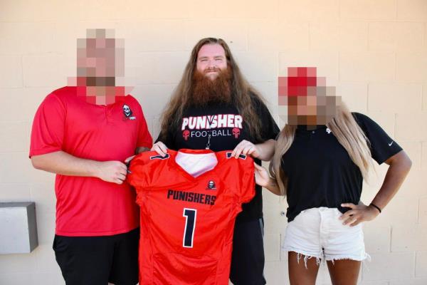 Co<em></em>ney is pictured wearing an Arkansas Punishers t-shirt and holding up a jersey.