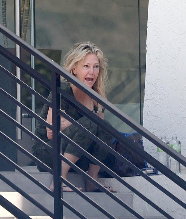 Heather Locklear sparks major fears for her perso<em></em>nal safety as she is seen precariously balancing herself along the edge of a tall office building whilst appearing to be in some sort of distress.