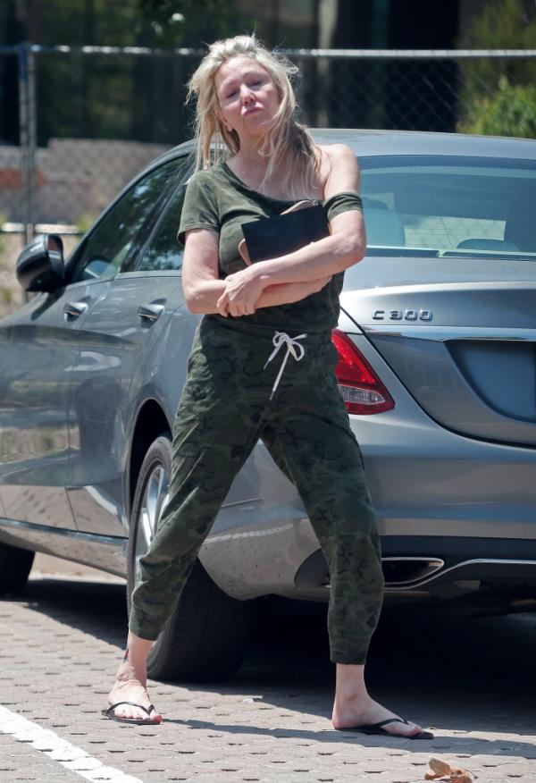 Heather Locklear sparks major fears for her perso<em></em>nal safety as she is seen precariously balancing herself along the edge of a tall office building whilst appearing to be in some sort of distress.