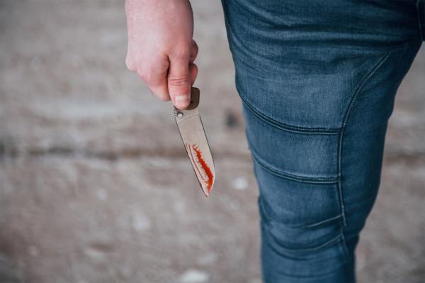 Someone holding knife with blood