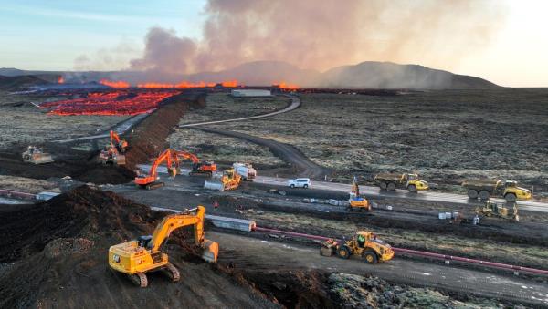Aerial view taken on January 14, 2024 shows emergency perso<em></em>nnel using diggers to build a protective wall trying to prevent flowing lava to reach the centre of the southwestern Icelandic town of Grindavik after a volcaninc eruption. 