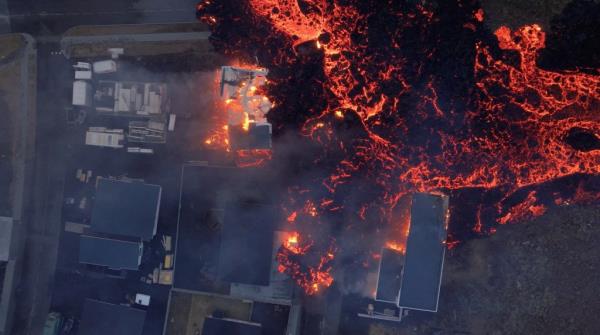 Lava flows from a volcano as houses burn in Grindavik, Iceland, January 14, 2024, in this screen grab obtained from a social media video.