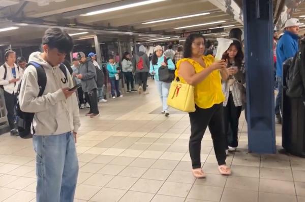 Straphangers are seen on the E train platform at Roosevelt Avenue-74th Street, wher<em></em>e a teen girl collapsed o<em></em>nto the tracks early Tuesday.