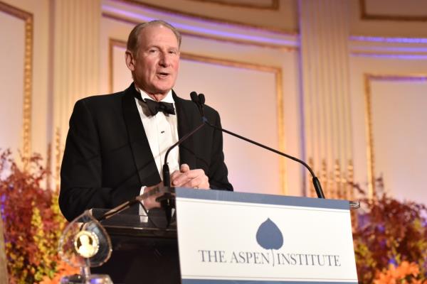 James Crown speaks at a podium in a tux at the Aspen Institute. 