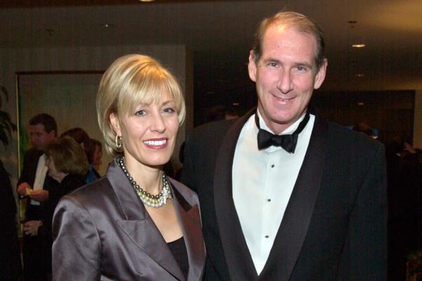 Paula and James Crown smile for a posed photo in dress attire. 