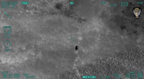 The pilot's plane camera caught sight of the little boy making his way through the field on Thursday.