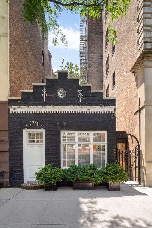 The Little House located at 78 Irving, just south of Gramercy Park, in  New York City.  Photo released July 26 2024. Check out this real life Up house for sale - a tiny home surrounded by skyscrapers in the heart of New York City.The three-bedroom 18th century property is one of three renovated carriage houses on the block.The house has been completely refurbished for a modern look and has three bathrooms.It is reminiscent of the Disney film Up - which features a tiny house surrounded by skyscrapers in a city. The main bedroom includes a walk-in wardrobe and en-suite bathroom with heated marble floors.