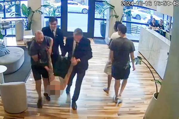 Hotel workers apparently haul Payne's unco<em></em>nscious body out of the lobby.