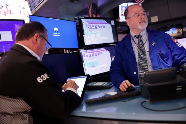 Traders work on the floor of New York Stock Exchange during morning trading on February 23, 2024.