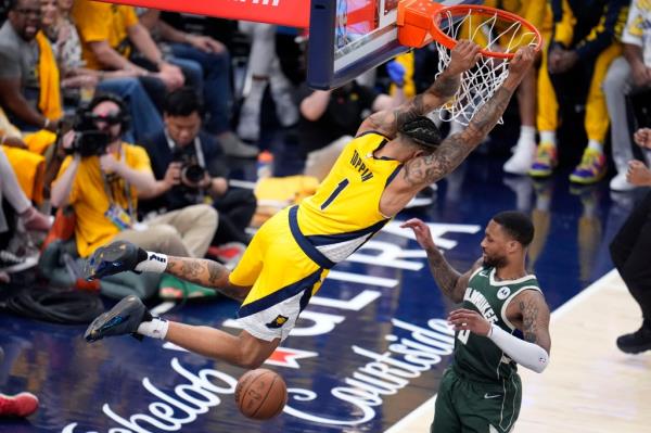 Indiana Pacers forward Obi Toppin (1) dunks the ball over Milwaukee Bucks guard Damian Lillard (0) during the second half in Game 6 in an NBA basketball first-round playoff series, Thursday, May 2, 2024, in Indianapolis.