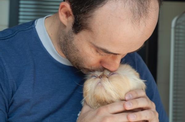 Man kissing cat
