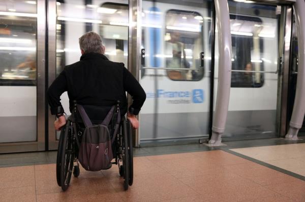 Man in wheelchair at subway track barrier in France