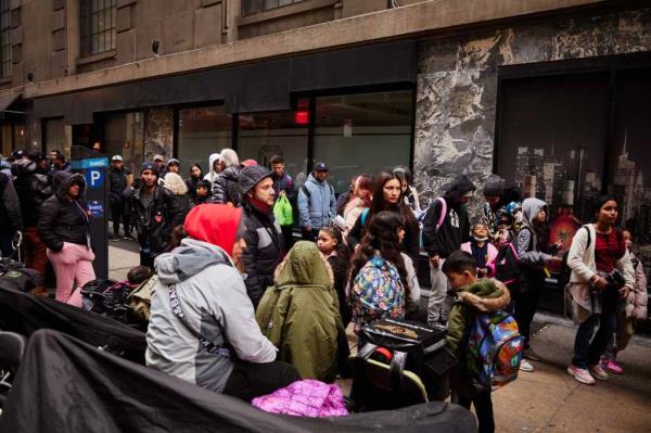 Migrants gather outside the Roosevelt Hotel -- the city's main intake center