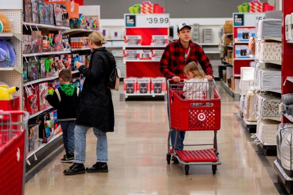 Shoppers in a Target store browsing aisles with a cart.