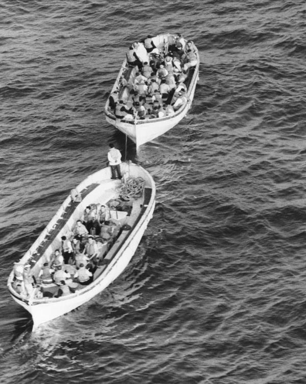 The captain and crewmen, who stayed with him until almost the end, head for rescue ship in lifeboats.
