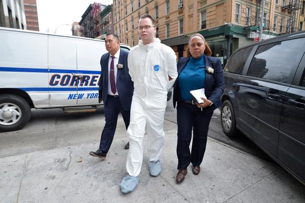 Alex Ray scott in white full body suit being led out of cop car