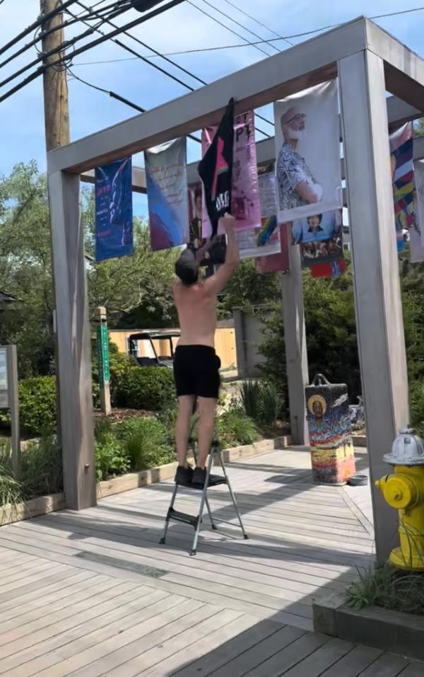 A man standing next to a flag ho<em></em>noring pro-Israel Rep. Ritchie Torres in Trailblazers Park, recently ripped down