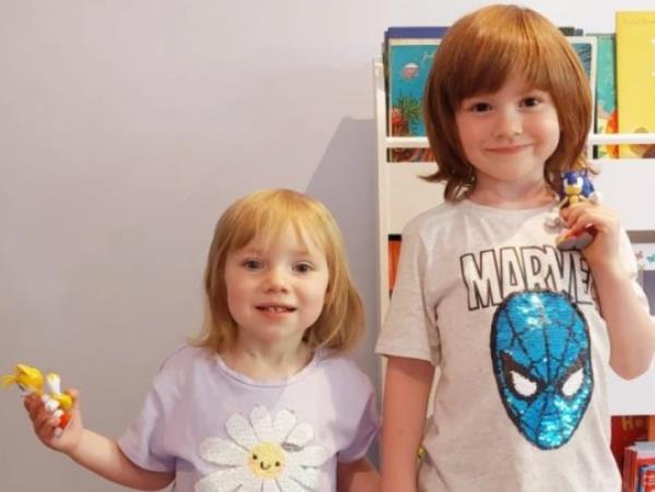 Sarah's children wearing a flower and Spider-man t-shirt, holding a toy each and looking to camera