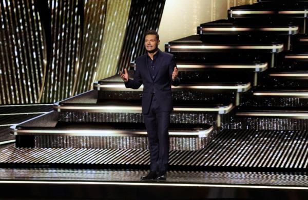 Ryan Seacrest hosting the 2024 Disney Legends Awards, standing onstage, smiling. 