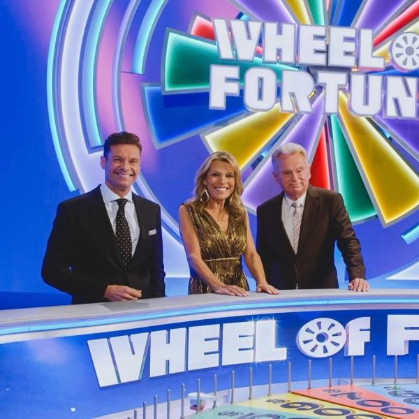Pat Sajak poses with Ryan Seacrest and Vanna White on the set of 