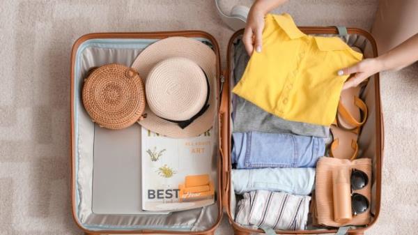 An overhead photo of a suitcase getting packed for a trip