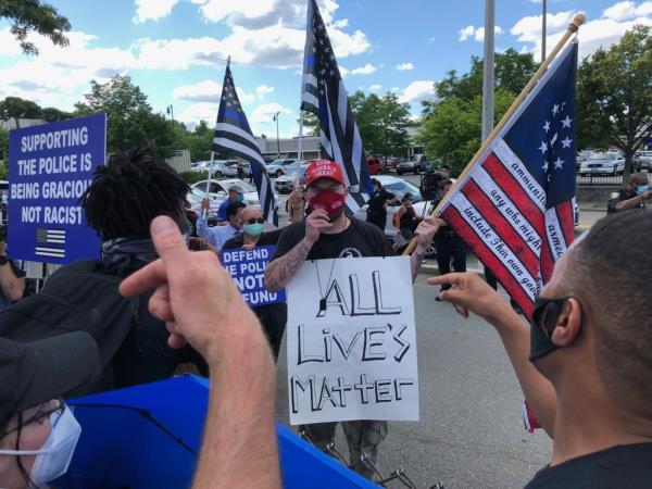 Protestors argue with a counter protester holding an