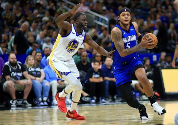 Paolo Banchero #5 of the Orlando Magic drives to the basket on Draymond Green #23 of the Golden State Warriors during a game at Kia Center on March 27, 2024 in Orlando. 