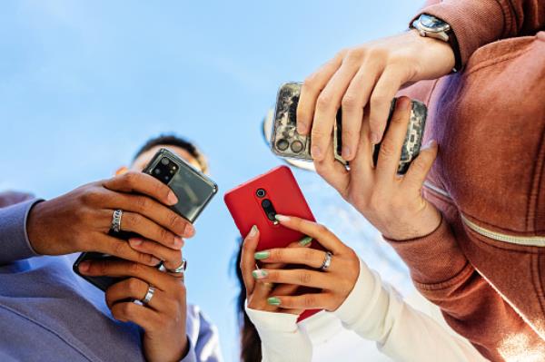 Group of friends using smartpho<em></em>nes