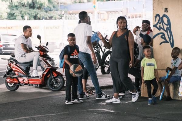 Migrants gather under the BQE, a block away from a migrant shelter on Ryerson Street.