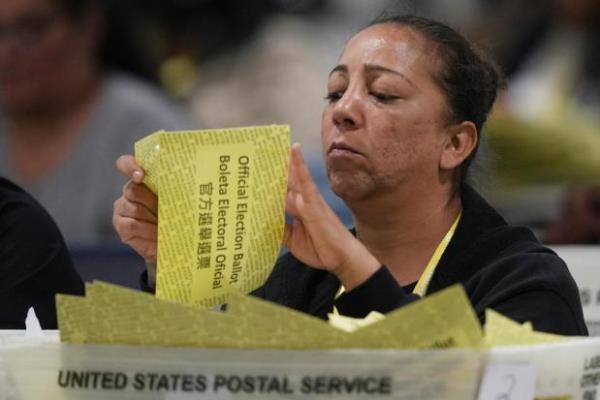An election worker processes mail-in ballots for the 2024 General Election at the Philadelphia Election Warehouse