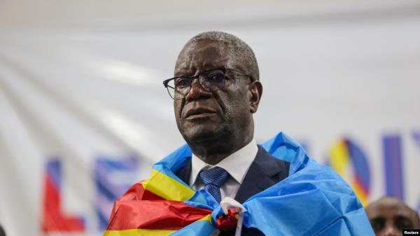 FILE - Democratic Republic of Co<em></em>ngo doctor and activist Denis Mukwege, who won the Nobel Peace Prize in 2018, stands wrapped in the natio<em></em>nal flag after he announced his candidacy for president in Kinshasa on Oct. 2, 2023.