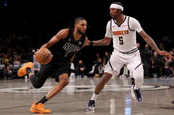 Nets forward Mikal Bridges (1) drives to the basket against Denver Nuggets guard Kentavious Caldwell-Pope