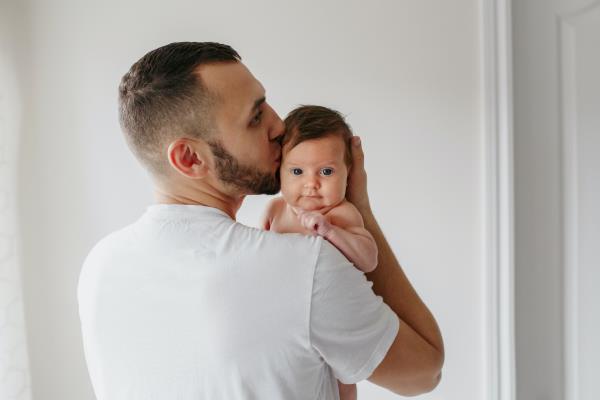 Young man kissing baby on head