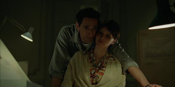 Adrien Brody leans against Felicity Jo<em></em>nes in The Brutalist still