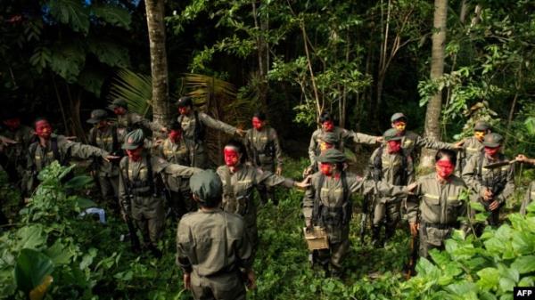 FILE - Guerrillas of the New People's Army (NPA) are seen in formation in the Sierra Madre mountain range, east of Manila, on July 30, 2017.