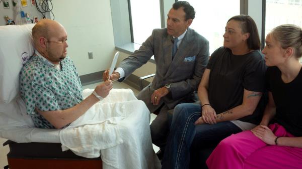 Aaron James looks at his face in a mirror for the first time after a whole-eye transplant in New York