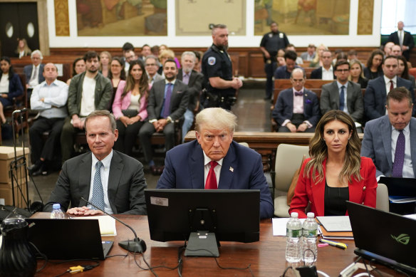 Former President Do<em></em>nald Trump, centre, sits in the courtroom with his legal team in the New York Supreme Court.