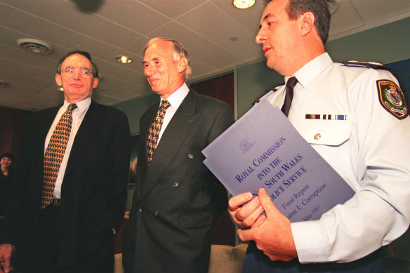 Justice James Wood (centre) hands over his royal commission report into NSW Police to premier Bob Carr in 1997. Police commissio<em></em>ner Peter Ryan holds the report.